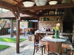 a patio with a table and chairs under a pavilion at Bóbita Apartmanház in Szilvásvárad