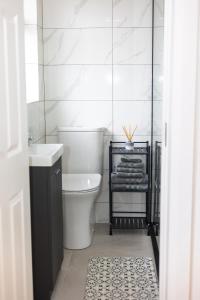 a white bathroom with a toilet and a sink at Inisfail in Killarney +10 photos