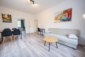 a living room with a couch and a table at Zentrale Wohlfühlwohnung - Ideal für Ihren Urlaub oder die Geschäftsreise in Magdeburg
