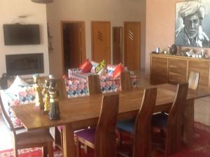 a dining room with a wooden table and a couch at DOMAINE VILLa in Tameslouht