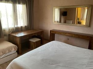 a bedroom with a bed and a mirror and a desk at DOMAINE VILLa in Tameslouht