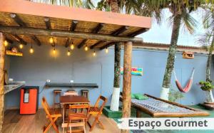 a restaurant with a table and chairs and palm trees at Hostel Praia Centro Itanhaém in Itanhaém