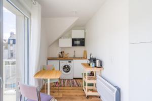 a small kitchen with a washer and dryer at Studio de la Plage des Dames - À 50 m de la plage in Douarnenez