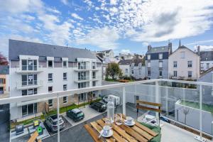 an apartment balcony with a table and a view of a parking lot at Studio de la Plage des Dames - À 50 m de la plage in Douarnenez