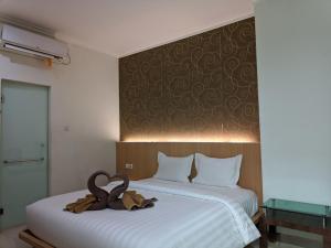 two beds in a hotel room with swans on them at The Cabin Hotel Wirobrajan in Yogyakarta