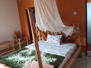 a wooden bed with a canopy in a room at Aunties Resort - Orutindo Kids Tantenlodge in Muhanga