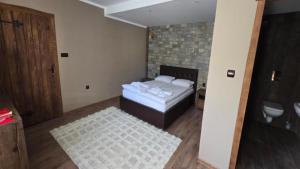 a bedroom with a bed and a bathroom at Къща за гости Велчева Завера in Samokov