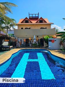a villa with a swimming pool in front of a house at Hostel Praia Centro Itanhaém in Itanhaém