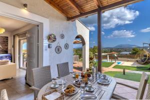a dining room with a table and chairs with a view at Villa Angelo Porto Heli - Private Pool in Porto Heli