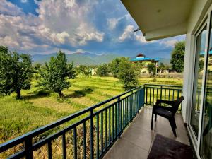 a balcony with a chair and a view of the mountains at Social Monkey Hostel Bir in Bīr