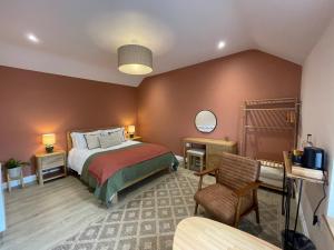 a bedroom with a bed and a chair at Rooms at Allium in Tenby