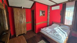 a bedroom with red walls and a bed in it at Къща за гости Велчева Завера in Samokov +27 photos
