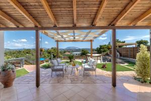a patio with chairs and a table with a view at Villa Angelo Porto Heli - Private Pool in Porto Heli