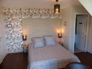 a bedroom with a bed with two pillows on it at LE RUBAN BLEU FACE A LA MER in Arromanches-les-Bains