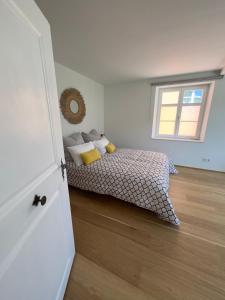 a bedroom with a bed with yellow pillows and a window at Maison Bleue Dreiländereck, Design Apartment mit Terrasse in historischem Landhaus nahe Basel in Kandern