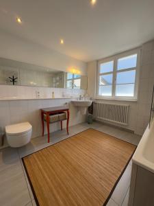 a bathroom with a toilet and a sink and a table at Maison Bleue Dreiländereck, Design Apartment mit Terrasse in historischem Landhaus nahe Basel in Kandern