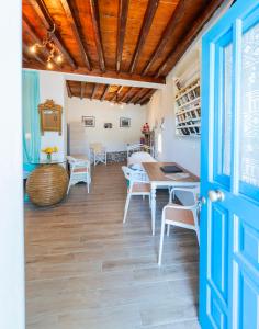 a room with a table and chairs and a blue door at Alexandra House in Kimolos