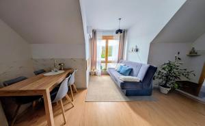 a living room with a blue couch and a wooden table at Domek za rzeką in Zawoja