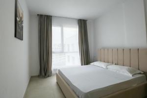 a bedroom with a bed and a large window at Crown Apartments in Golem +53 photos