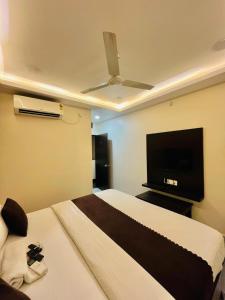 a bedroom with a bed and a flat screen tv at Hotel MK in Ratlām