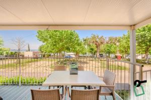 a table and chairs on a deck with a view of a park at Hotiday Lazise Garda in Lazise