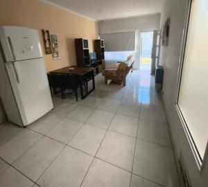 a kitchen and living room with a refrigerator and a table at Depto Civora 2 in Villa Regina +1 photo