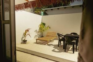 a patio with a bench and a table and chairs at Ari Paradise in Hangnaameedhoo