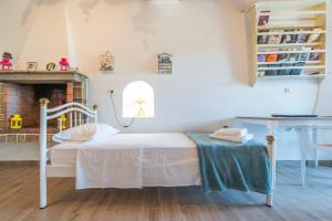 a bedroom with a bed and a table and a fireplace at Alexandra House in Kimolos +3 photos