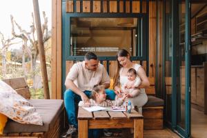 a family sitting on a table with two babies at TAIGA Bassegoda Park in Albanya