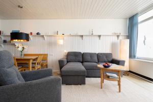 a living room with a couch and a table at StrandMöwe in Burgtiefe auf Fehmarn  +30 photos