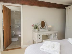 a bedroom with a white bed and a bathroom at Barn Howe in Kendal +79 photos