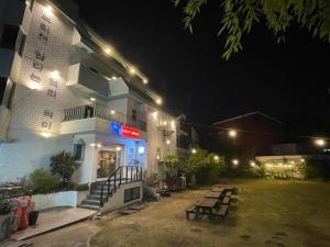 a building with benches in front of it at night at Suncheon Guest House Nreem in Suncheon
