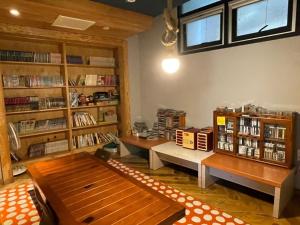 a living room with two benches and book shelves at Suncheon Guest House Nreem in Suncheon