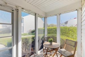 a screened in porch with a table and chairs at Sunset Village 31E in Ocean City