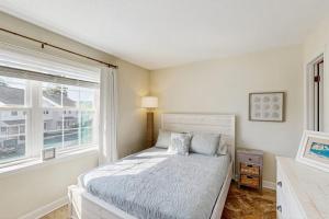a white bedroom with a bed and a window at Sunset Village 31E in Ocean City