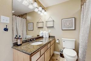 a bathroom with a sink and a toilet and a mirror at Sunset Village 31E in Ocean City +9 photos
