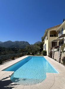 a large blue swimming pool next to a building at Des Ciappes et des Fées in Menton