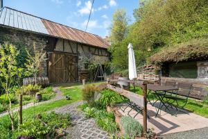 a garden with a table and an umbrella in front of a building at Toms Hütte in Udler