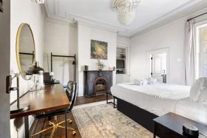 a bedroom with a bed and a desk and a fireplace at King Suite 2nd FloorHotel Boutique in Savannah +13 photos