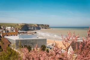 a view of a beach with a building and the ocean at Le chant des oiseaux in Ryes