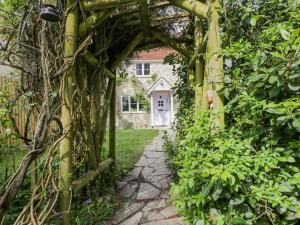 an archway covered in vines in front of a house at Lavender Cottage in Gillingham