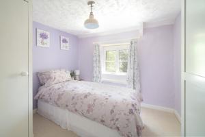 a bedroom with a bed and a window at Lavender Cottage in Gillingham