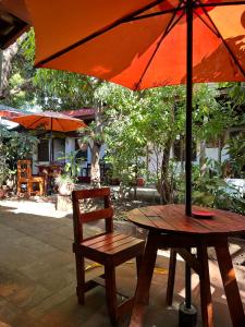 a wooden table with a chair and an umbrella at Casa de Los Berrios in León +49 photos