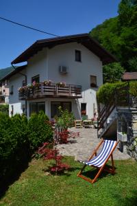 a house with a chair in front of it at Apartmaji Grapa in Most na Soči