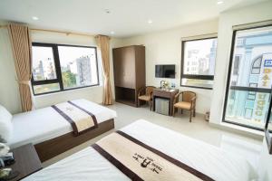 a hotel room with two beds and a desk at Thăng Long II hotel FLC in Lôc Hải +4 photos