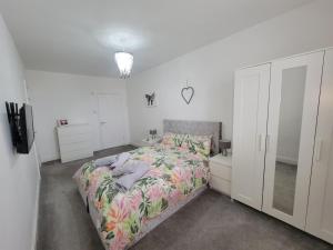 a white bedroom with a bed and a desk at Cwtch y Môr - NEW Outdoor Pool Spacious 3 bed, sea & mountain views in Holy Island