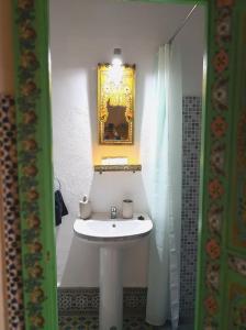 a bathroom with a white sink and a mirror at Riad la madriguera de Tetuan in Tétouan