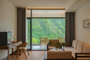 a living room with a couch and a large window at Zhangjiajie National Park Nvue Resort Free Laundry & Dry Service,Free Fresh coffee& Customizing Tour Plan in Zhangjiajie