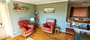 a living room with two chairs and a shelf at The Hirsel on Skye in Ord +12 photos