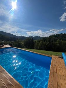 a blue swimming pool with a view of the mountains at Nagoru house in Tukhlya